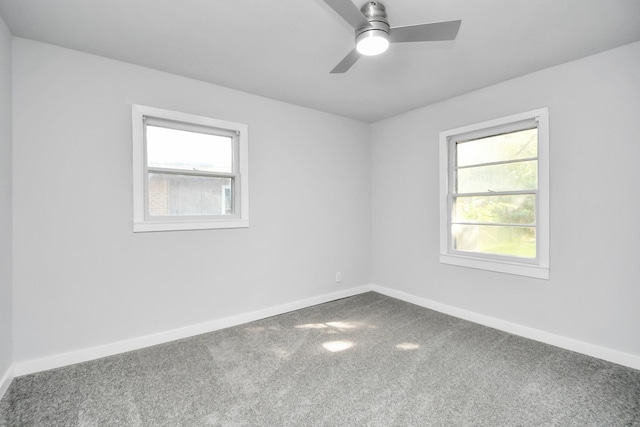 carpeted spare room featuring a wealth of natural light and ceiling fan