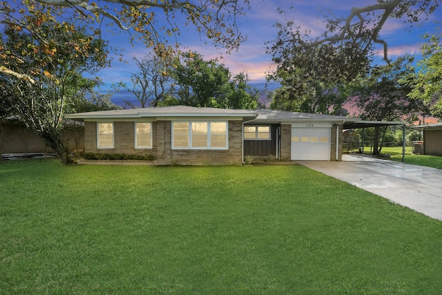 ranch-style house featuring a yard, a garage, and a carport