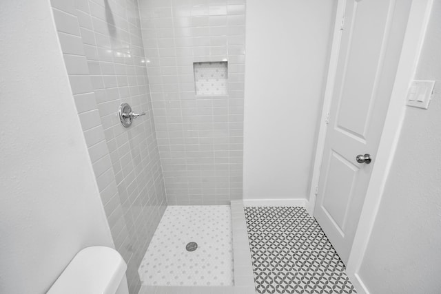 bathroom with toilet and tiled shower