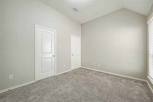 unfurnished room featuring dark colored carpet and vaulted ceiling