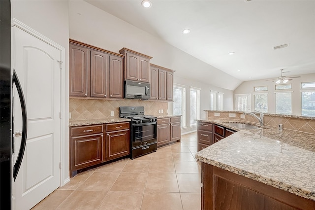 kitchen with black gas range, ceiling fan, sink, refrigerator, and vaulted ceiling