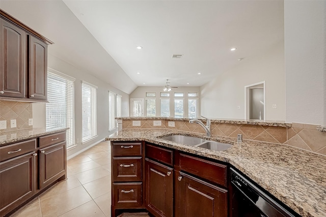 kitchen featuring a wealth of natural light, sink, vaulted ceiling, and black dishwasher