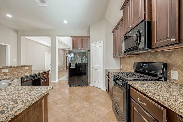 kitchen with tasteful backsplash, light stone counters, sink, black appliances, and light tile patterned floors