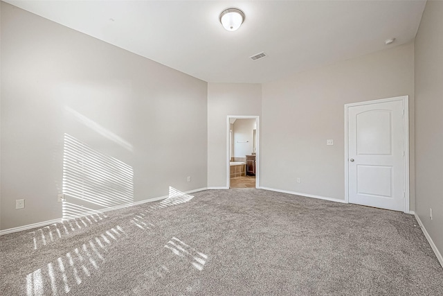 unfurnished bedroom with ensuite bathroom and light colored carpet