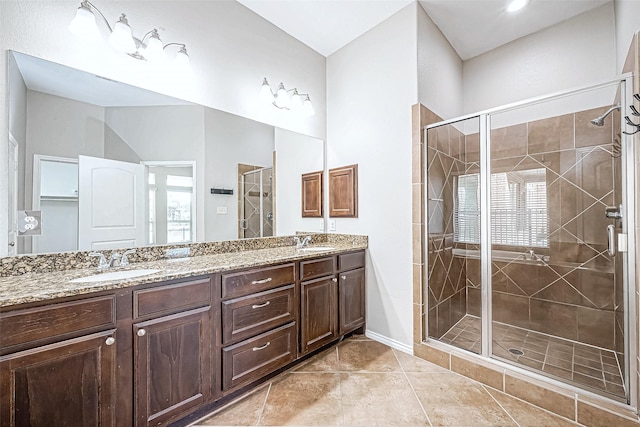 bathroom with tile patterned flooring, vanity, and walk in shower