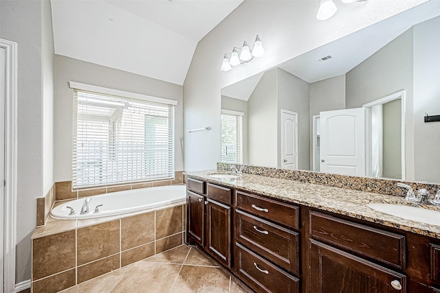 bathroom featuring tile patterned flooring, vanity, tiled tub, and vaulted ceiling