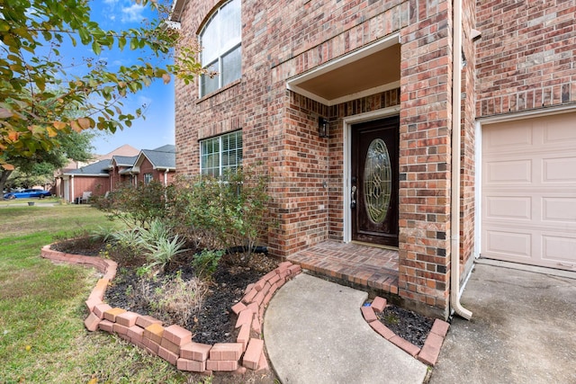 property entrance with a lawn and a garage