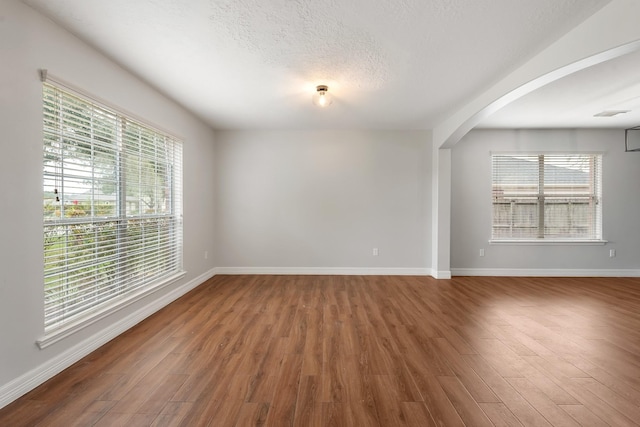 unfurnished room with wood-type flooring and a textured ceiling