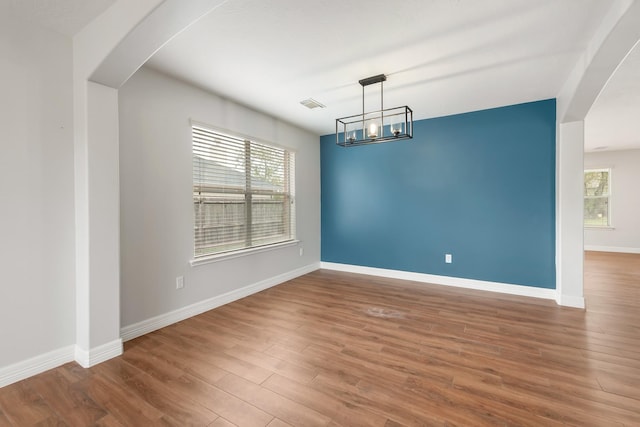 unfurnished dining area featuring hardwood / wood-style floors and a notable chandelier