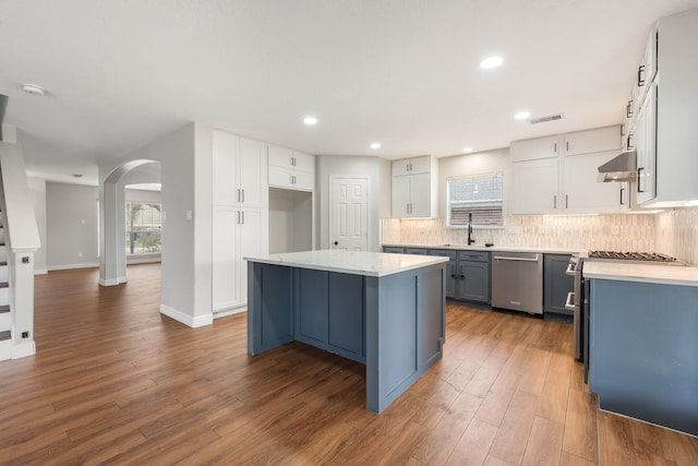 kitchen with a center island, sink, dark hardwood / wood-style flooring, white cabinetry, and stainless steel appliances