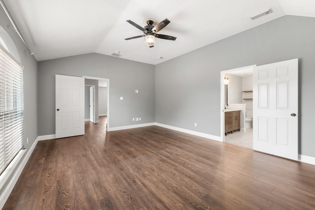 unfurnished bedroom featuring ceiling fan, dark hardwood / wood-style flooring, connected bathroom, and vaulted ceiling