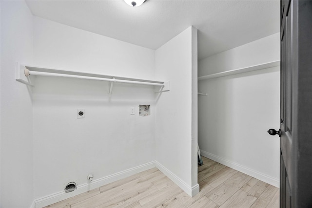 laundry room with hookup for an electric dryer, hookup for a washing machine, light wood-type flooring, and gas dryer hookup