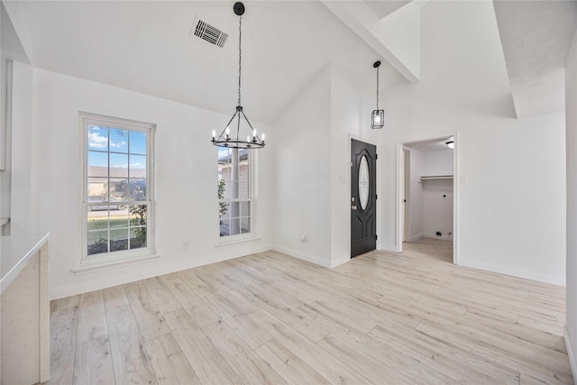 unfurnished dining area with beamed ceiling, high vaulted ceiling, light hardwood / wood-style floors, and an inviting chandelier