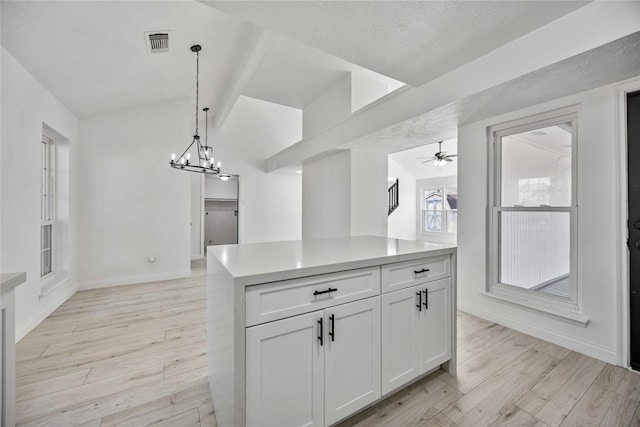 kitchen featuring ceiling fan with notable chandelier, white cabinets, light hardwood / wood-style floors, and decorative light fixtures