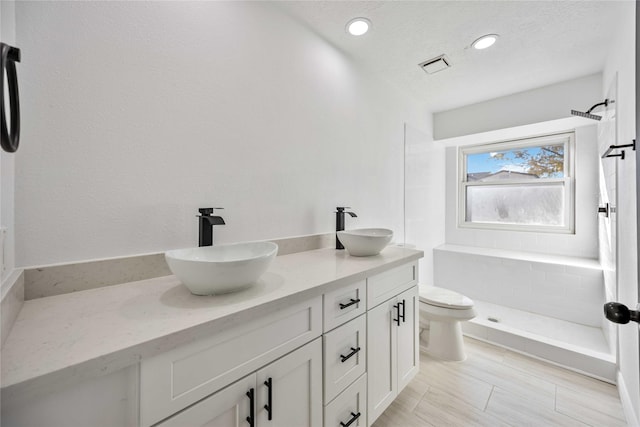 bathroom featuring a shower, vanity, and toilet