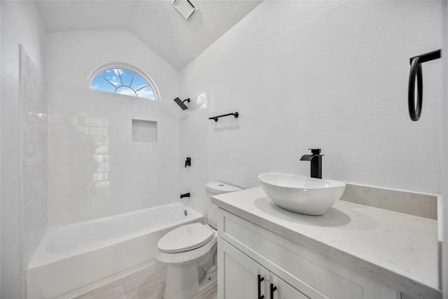 full bathroom featuring tiled shower / bath combo, a textured ceiling, lofted ceiling, toilet, and vanity