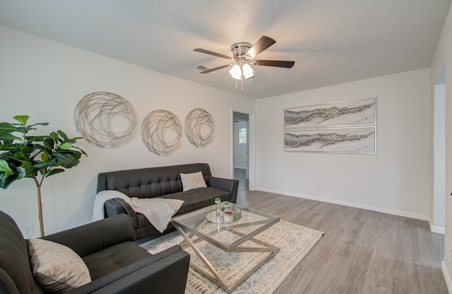 living room with light hardwood / wood-style floors and ceiling fan