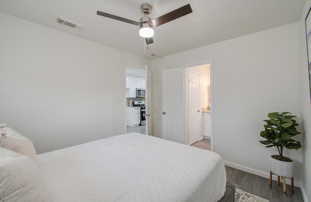 bedroom featuring hardwood / wood-style floors, ceiling fan, and ensuite bathroom