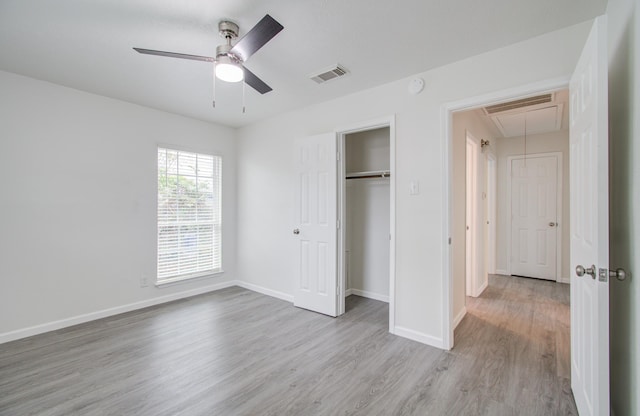 unfurnished bedroom with ceiling fan, a closet, and light wood-type flooring