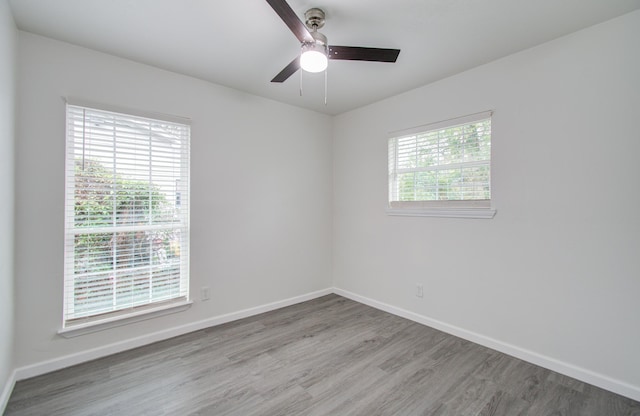 unfurnished room with hardwood / wood-style floors, ceiling fan, and a wealth of natural light