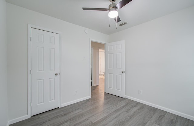 unfurnished bedroom with ceiling fan, a closet, and light hardwood / wood-style floors