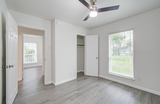 unfurnished bedroom with light hardwood / wood-style flooring, multiple windows, and ceiling fan