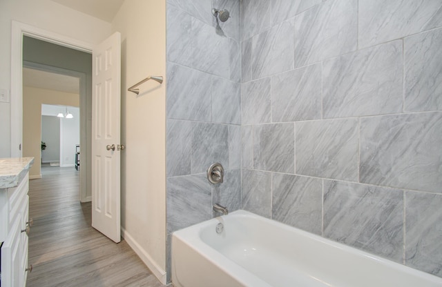 bathroom featuring vanity, tiled shower / bath combo, and hardwood / wood-style flooring