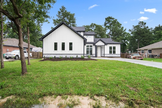 modern farmhouse style home with a front yard and cooling unit