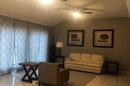 living room featuring ceiling fan and vaulted ceiling