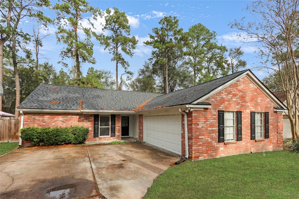 ranch-style home with a garage and a front yard