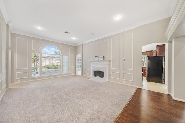 unfurnished living room with carpet and crown molding