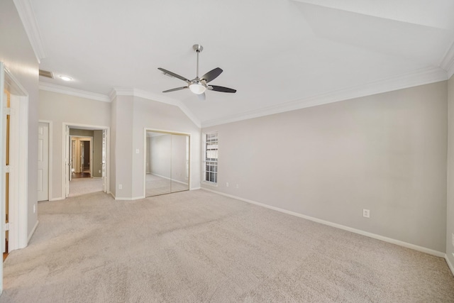 unfurnished bedroom with crown molding, vaulted ceiling, ceiling fan, light colored carpet, and a closet