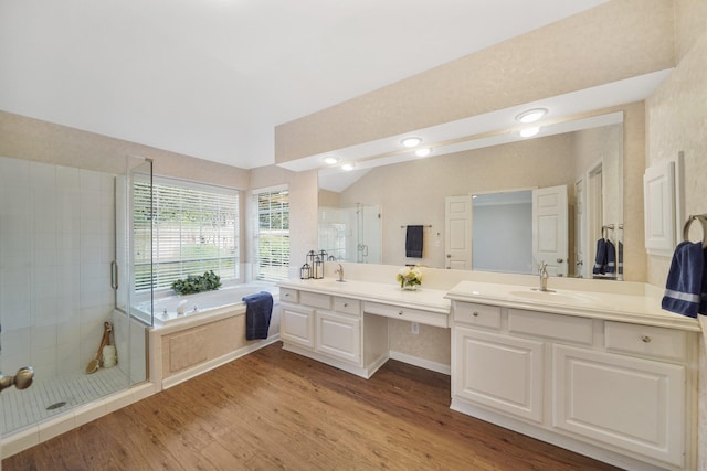 bathroom featuring wood-type flooring, vanity, shower with separate bathtub, and lofted ceiling