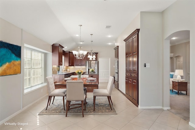 tiled dining room featuring lofted ceiling, sink, and a chandelier