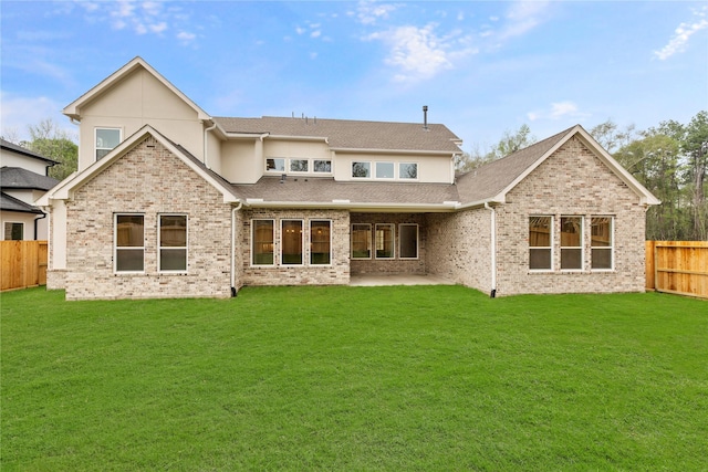 back of property with a yard and a patio