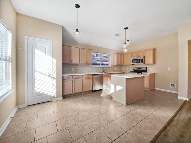 kitchen with a wealth of natural light, a center island, stainless steel appliances, and decorative light fixtures