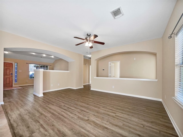 unfurnished living room with dark hardwood / wood-style floors and ceiling fan