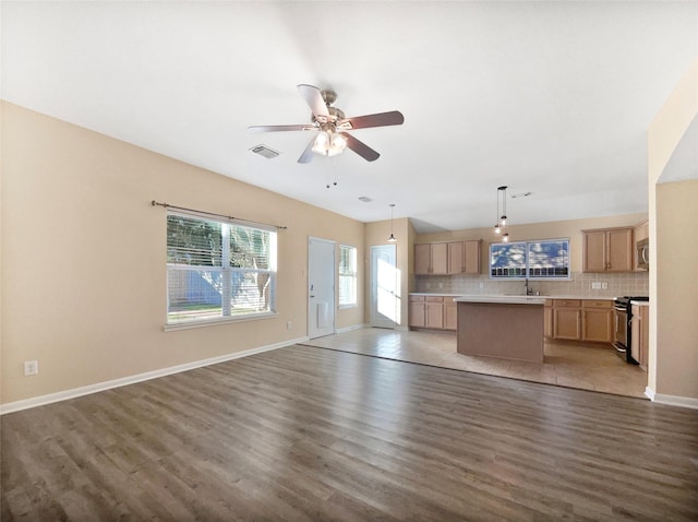 unfurnished living room featuring ceiling fan, dark wood-type flooring, and sink