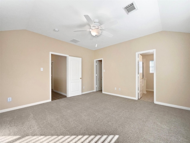 unfurnished bedroom with carpet floors, ensuite bathroom, ceiling fan, and lofted ceiling