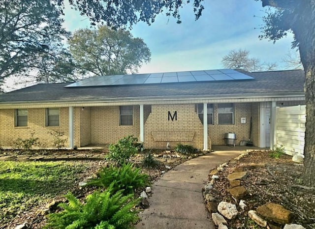 back of house featuring solar panels