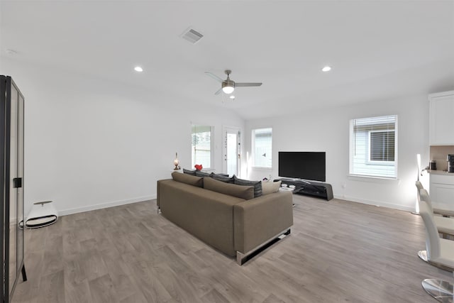 living room featuring ceiling fan, light hardwood / wood-style floors, and lofted ceiling