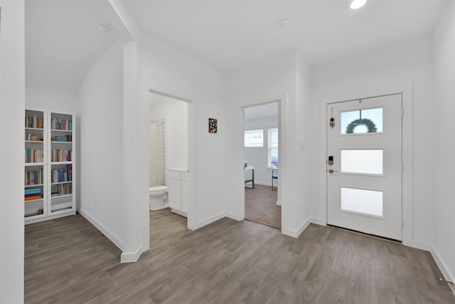 entrance foyer featuring light hardwood / wood-style floors and lofted ceiling