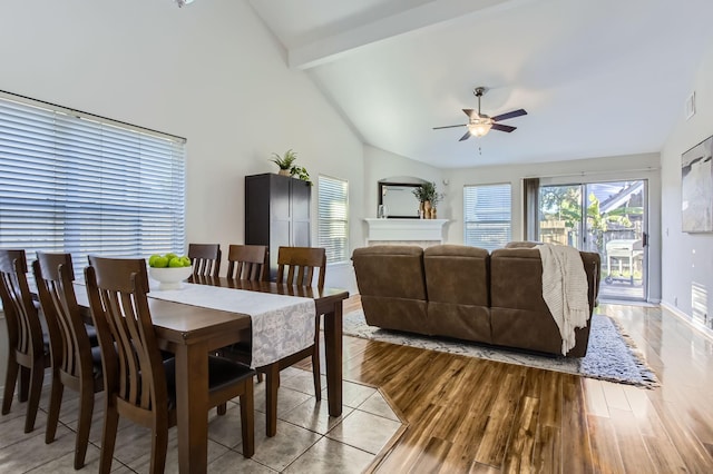 dining room with beam ceiling, light hardwood / wood-style floors, high vaulted ceiling, and ceiling fan