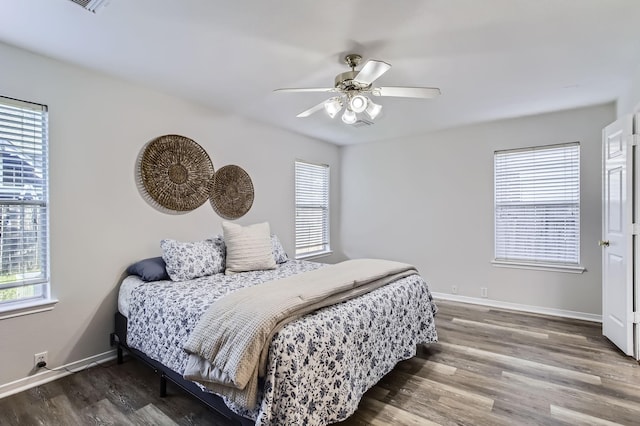 bedroom with hardwood / wood-style flooring, ceiling fan, and multiple windows