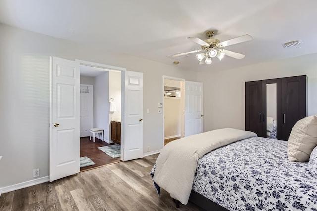 bedroom with ceiling fan, hardwood / wood-style floors, and ensuite bathroom