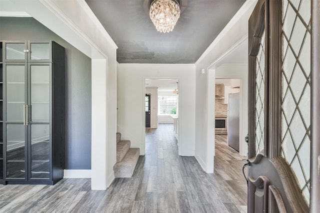 hallway with a chandelier and hardwood / wood-style floors