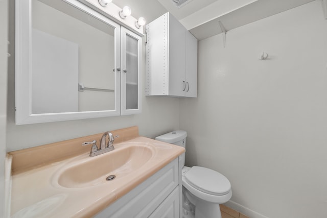 bathroom featuring tile patterned flooring, vanity, and toilet