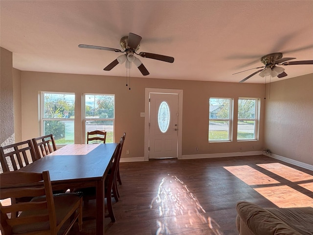 unfurnished dining area featuring plenty of natural light, dark wood-type flooring, and ceiling fan