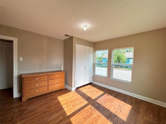 unfurnished bedroom with dark wood-type flooring