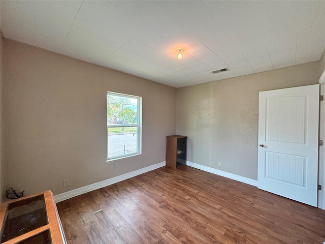 unfurnished room with dark wood-type flooring